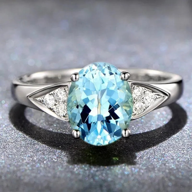 A women's court style ring with a natural zircon stone in a heart, water drop, or bell pattern, shown in blue, red, green, or light blue.