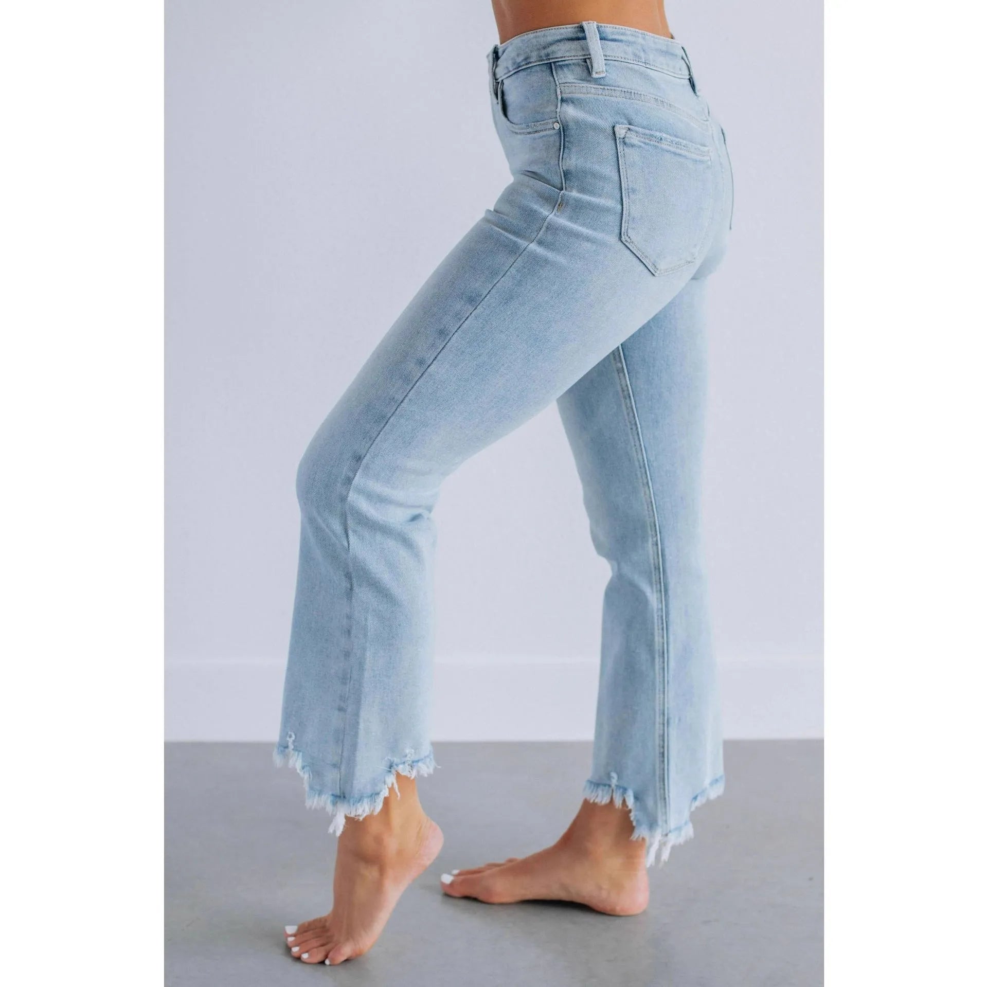 Women's solid colour denim jeans with hand-worn distressing in dark blue, laid flat.
