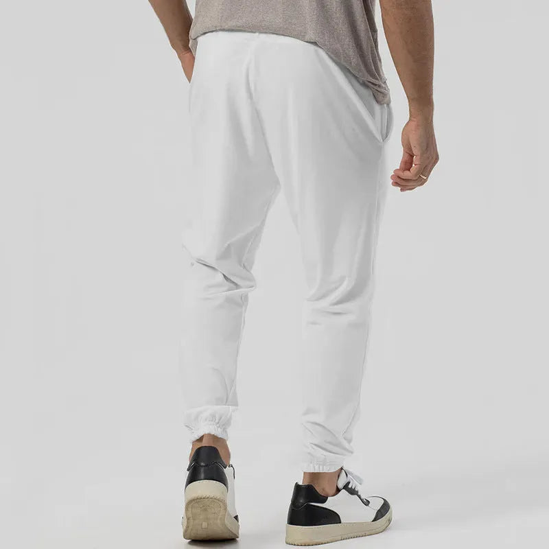 Man wearing grey straight-leg casual track sweatpants with an elasticated waist and micro-elastic fabric.