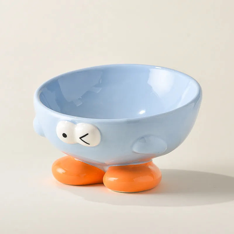 Ceramic slanted pet bowl with cute expression design in blue, yellow, and set colours for cervical spine support.