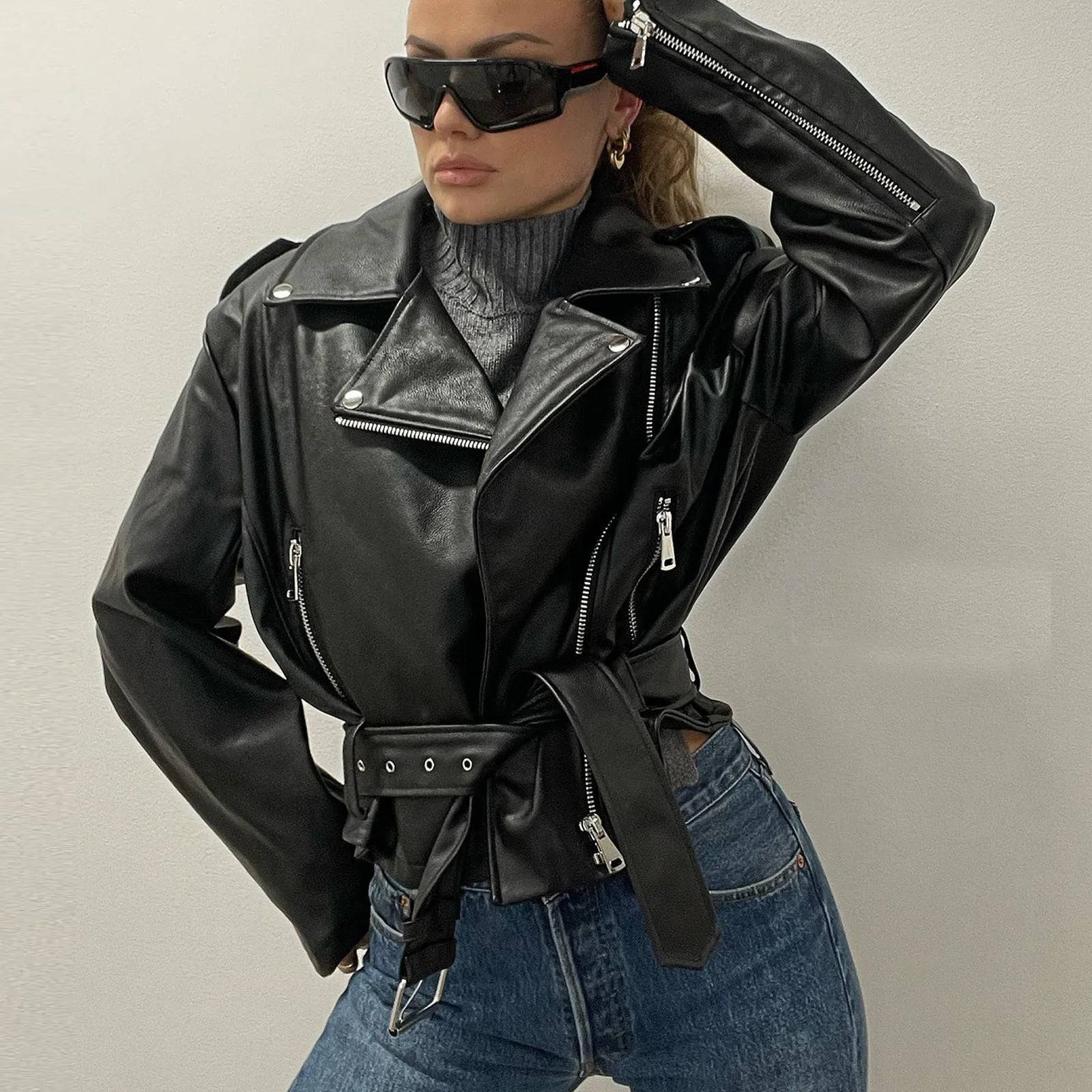 Black leather-style punk jacket with a Peter Pan collar and a drawstring waist, laid flat.