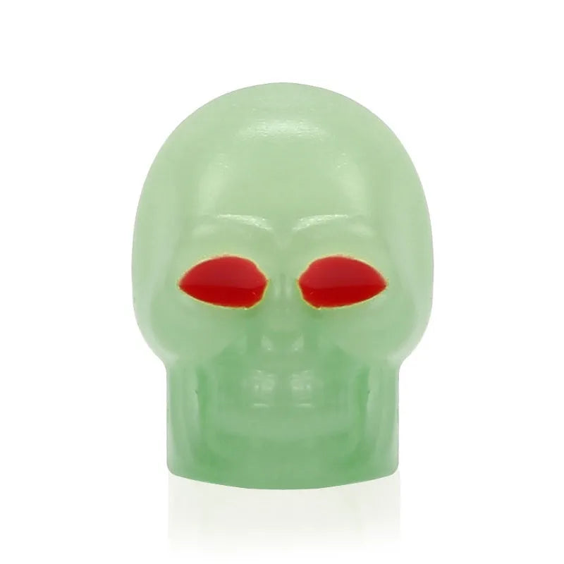 Luminous skull-shaped rubber car tyre valve cap in glow effect on a standard wheel