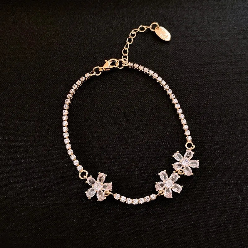 Gold-coloured women's bracelet with geometric quadrilateral design and zircon stone inlay