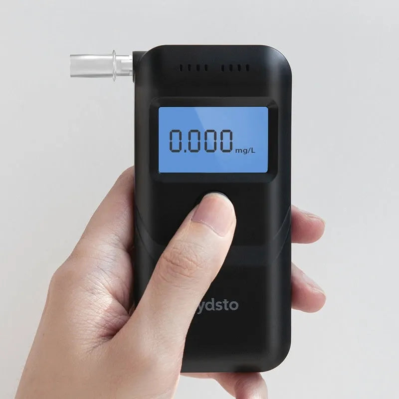 Black portable digital breath alcohol tester on a white background