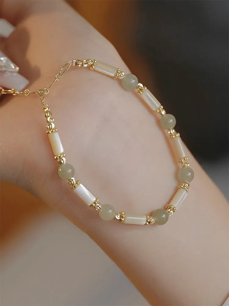 Women's green Hetian jade bracelet with a bamboo joint design.