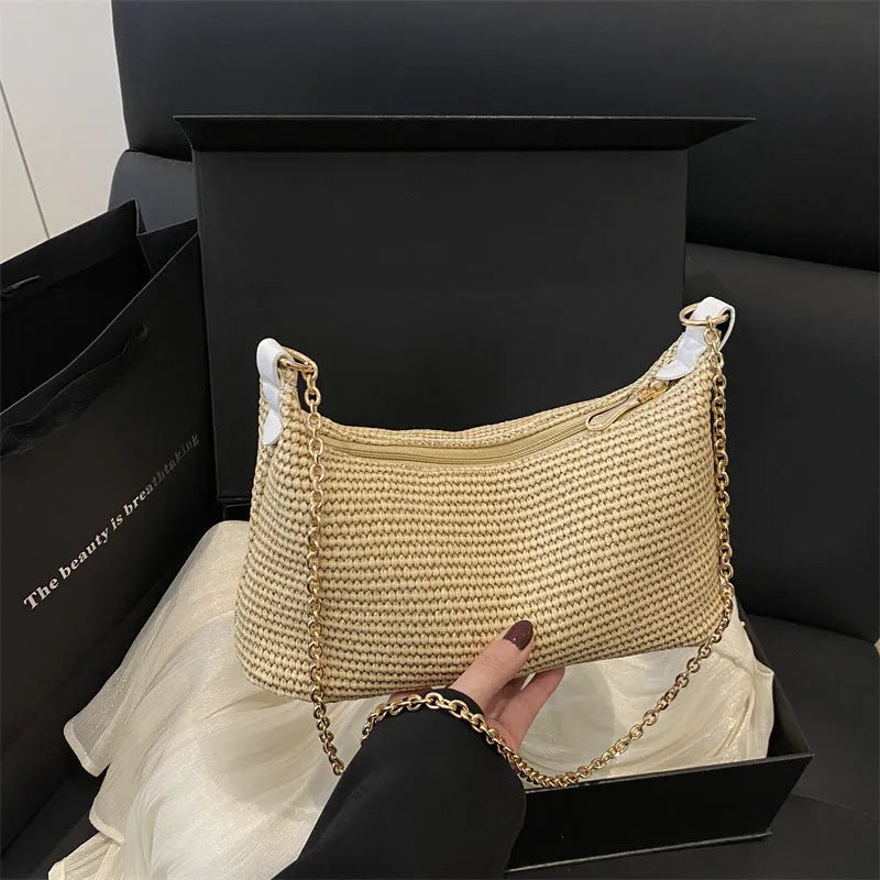 Woven straw beach shoulder tote bag in khaki colour with visible stitching and an outer pocket.