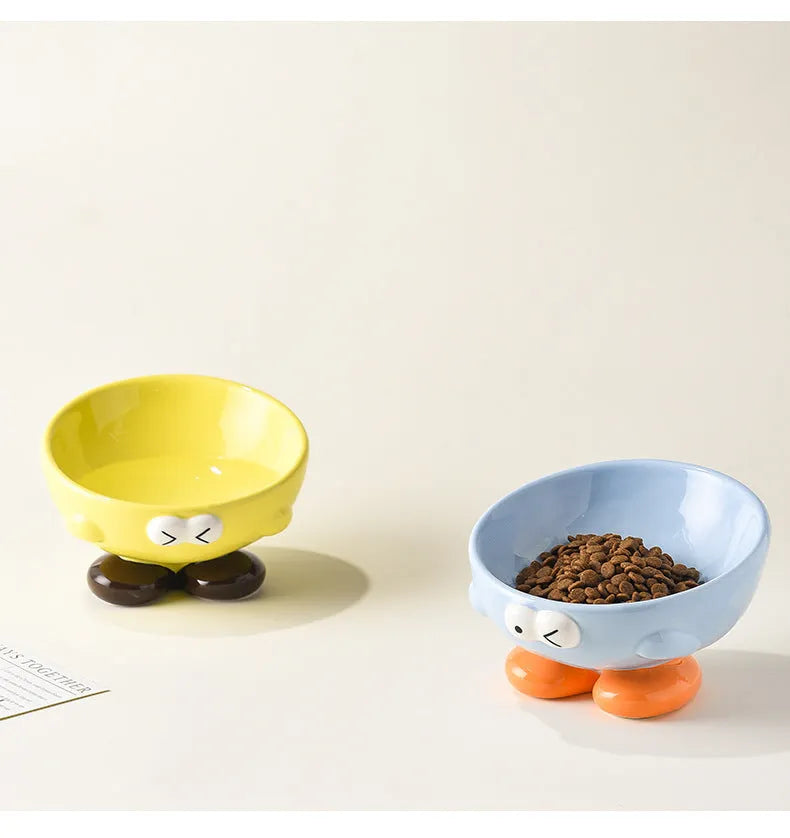 Ceramic slanted pet bowl with cute expression design in blue, yellow, and set colours for cervical spine support.
