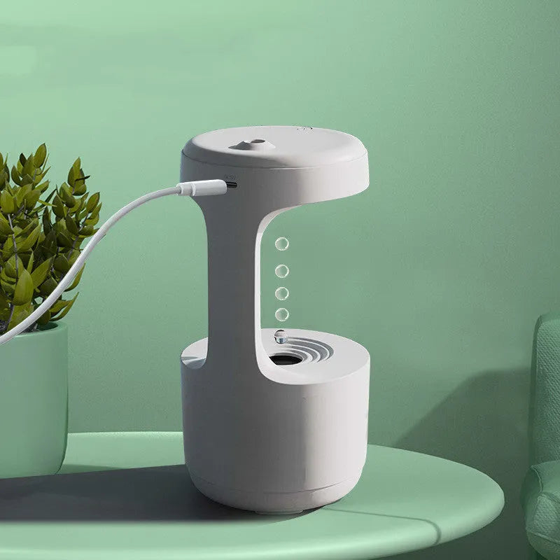 White columnar anti-gravity humidifier on a desk with LED clock display and visible mist.