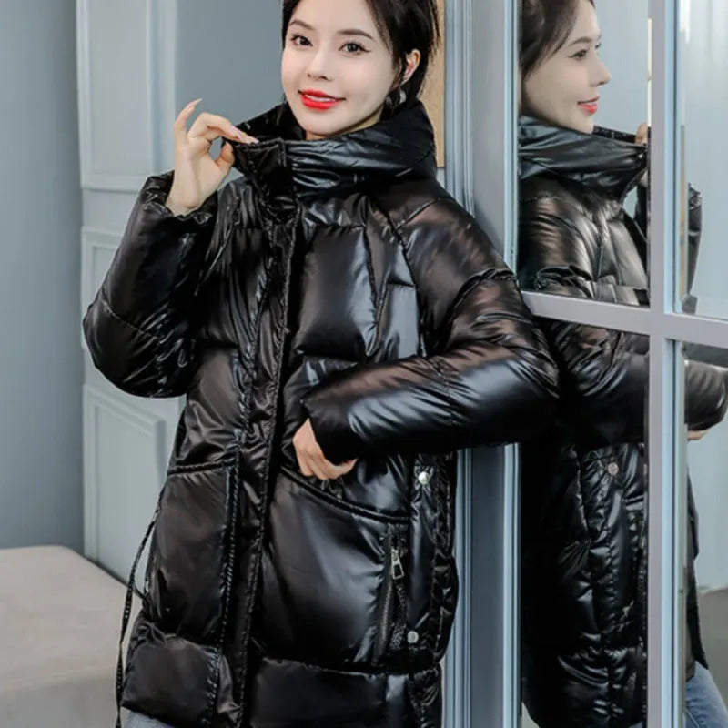 Women's loose-fit green hooded winter jacket with long sleeves on a hanger.