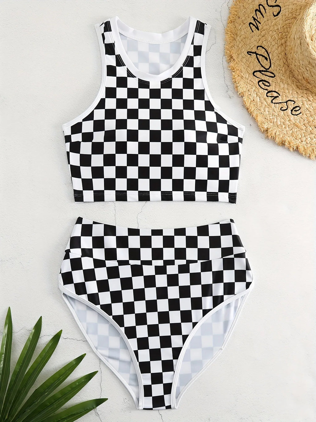 Women's backless one-piece swimsuit with black and white chessboard pattern and sporty suspender straps.