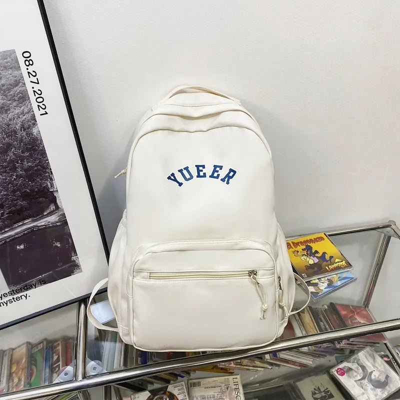 Simple nylon backpack for women, 32cm, with computer pocket, in five colours including black, blue, red, white, and light green.