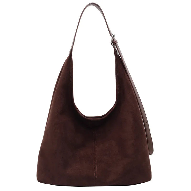 Women's suede bucket bag in black with stitching detail, single shoulder strap, and outer sandwich pocket