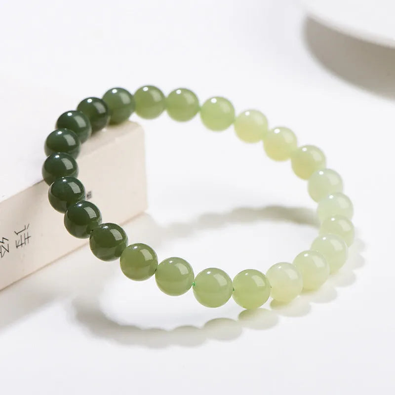 Natural clear water Hetian jade bracelet with round beads and barrel bead options on a wrist.