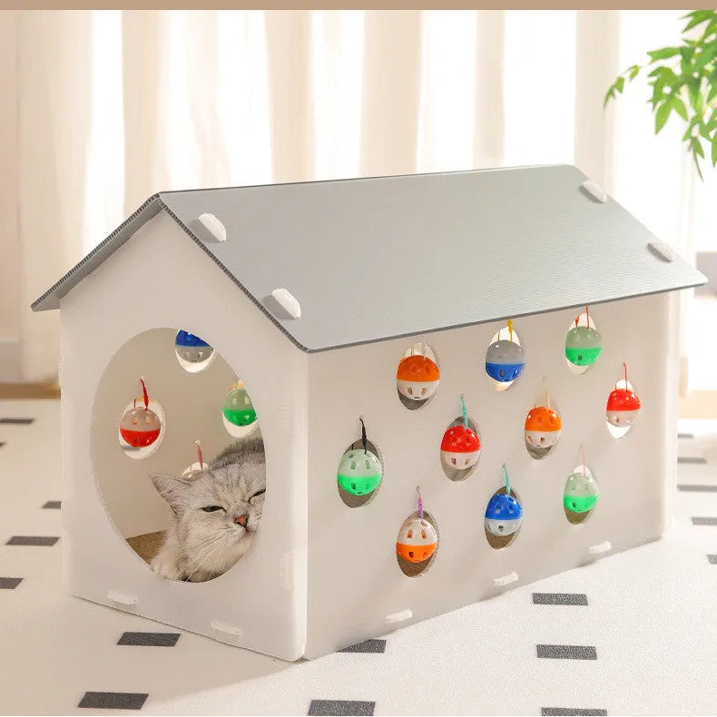 White plastic cat scratch board with integrated enclosed nest, tunnel, and hanging bell ball toy.