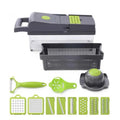 Grey stainless steel vegetable cutter with multiple blades and accessories on kitchen work surface