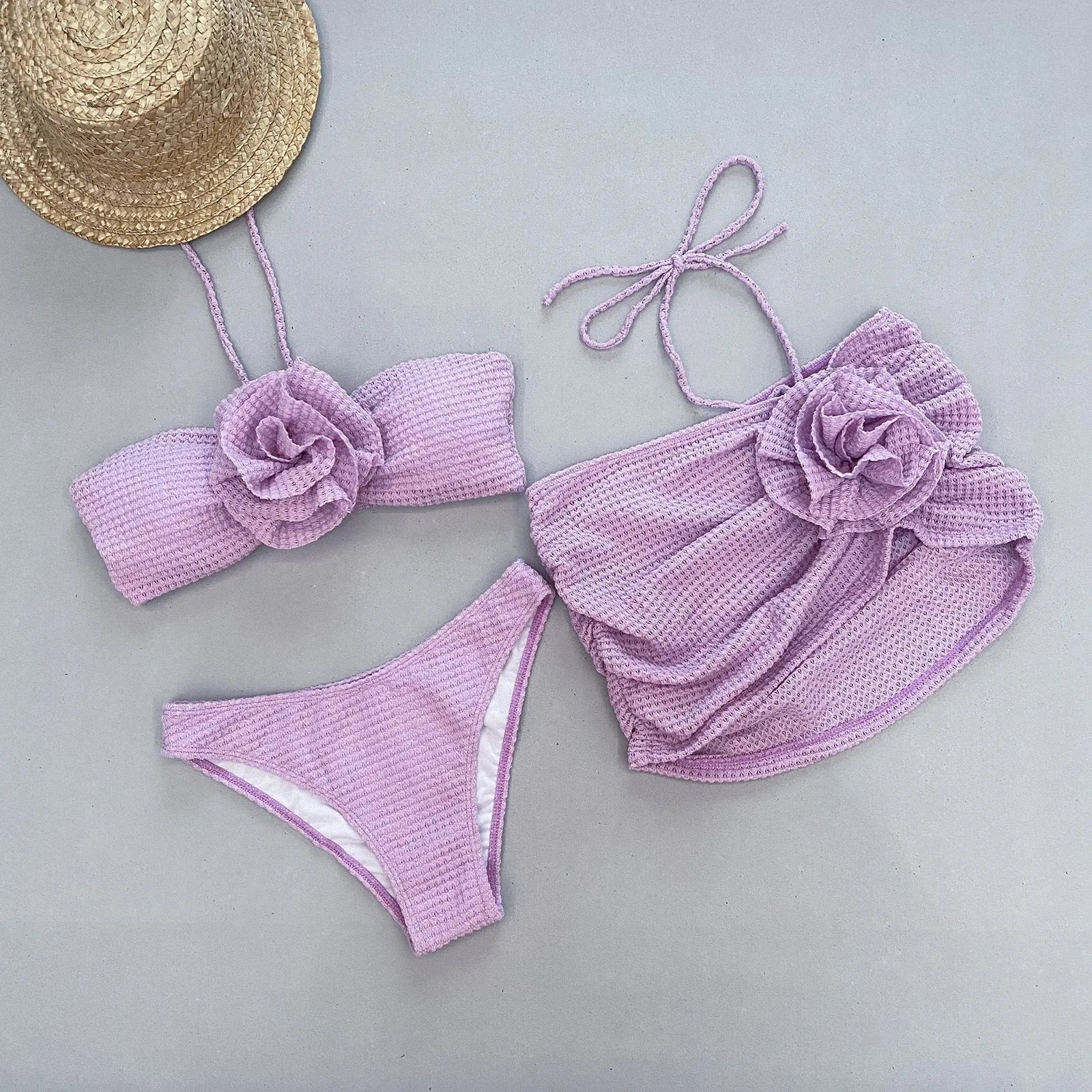Women's white three-piece bikini swimsuit with separate bra, panties, and skirt on hanger
