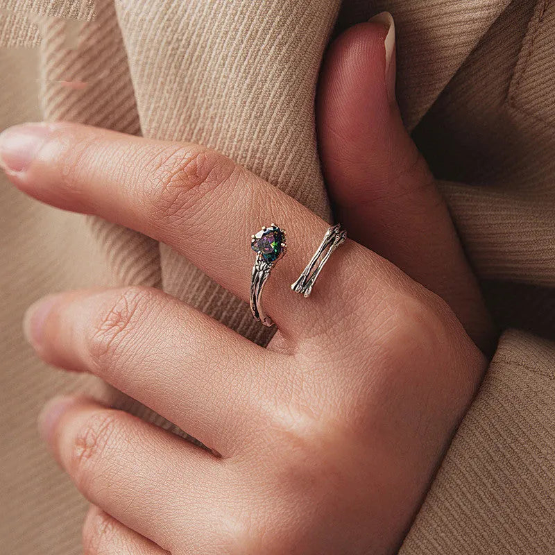 Adjustable silver skull hand ring with heart shaped base and pumpkin skull detail on white background