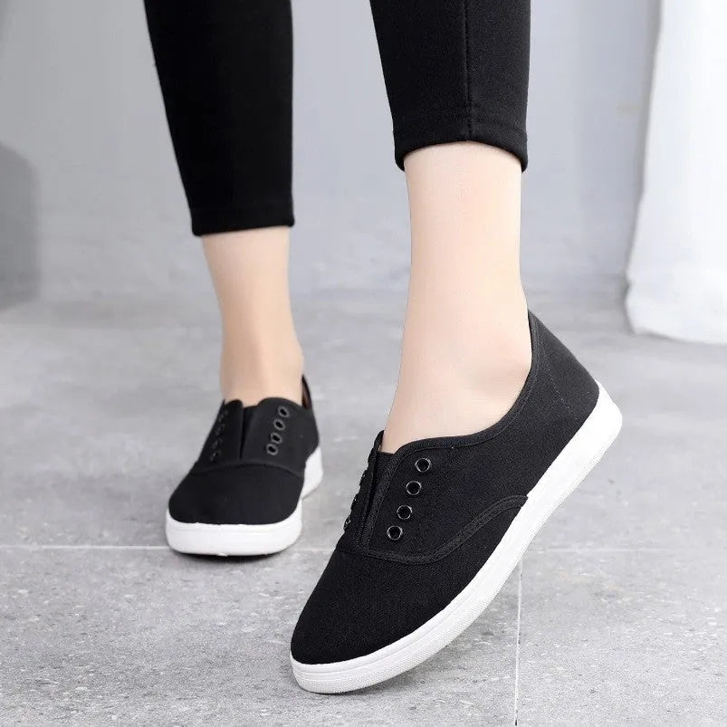 Low-top canvas casual shoes in black, featuring a flat heel and plastic sole.