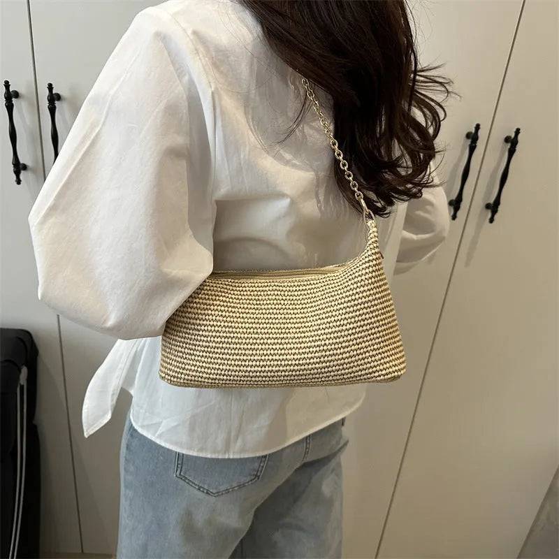 Woven straw beach shoulder tote bag in khaki colour with visible stitching and an outer pocket.