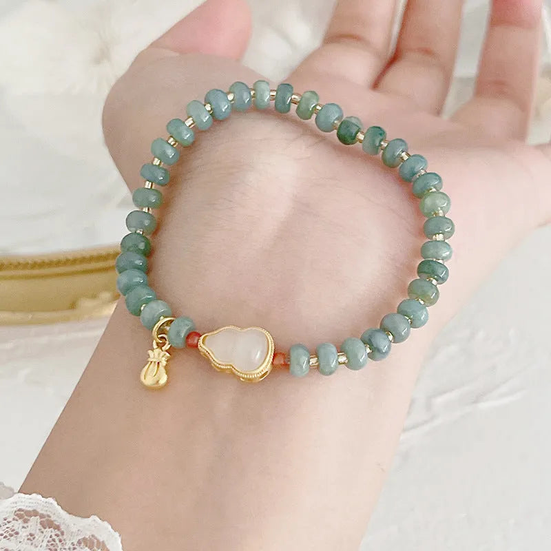 Women's simple jade bracelet with blue gourd charm and silver peace buckle on a beaded strand.
