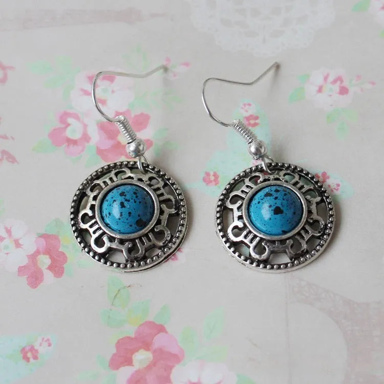 Handmade Miao silver geometric flower disk earrings with turquoise and auspicious cloud patterns in red, blue, black.