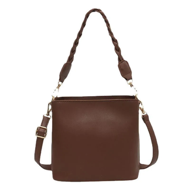 Retro khaki woven crossbody bucket bag with adjustable strap shown worn on shoulder