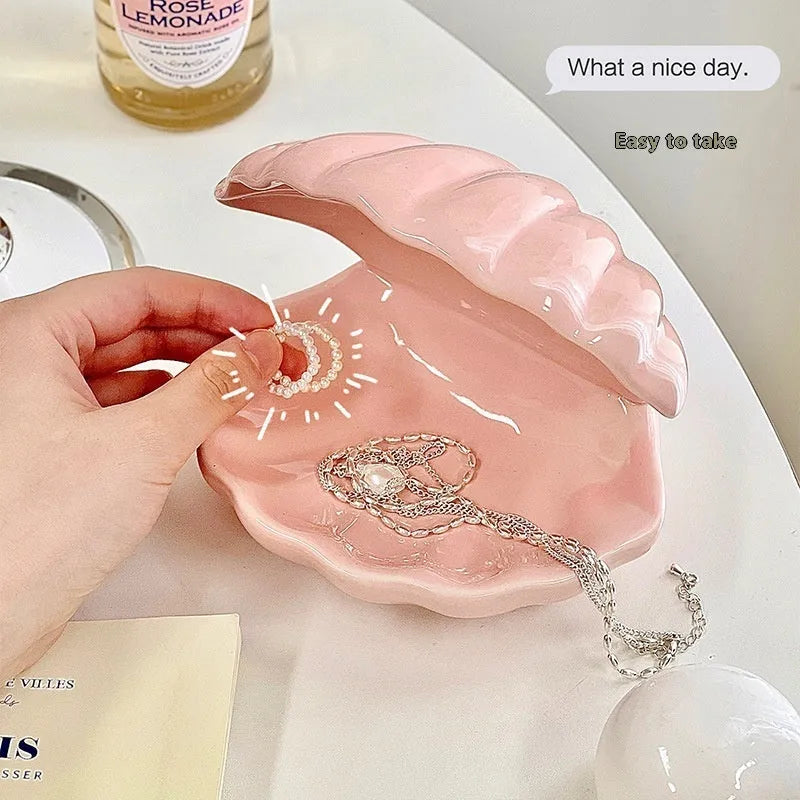 White porcelain decorative storage tray with a small built-in night light, holding jewellery on a bedside table