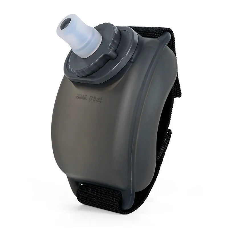 Orange wrist water bottle with Velcro strap and bite valve, shown mounted on wrist for running or cycling
