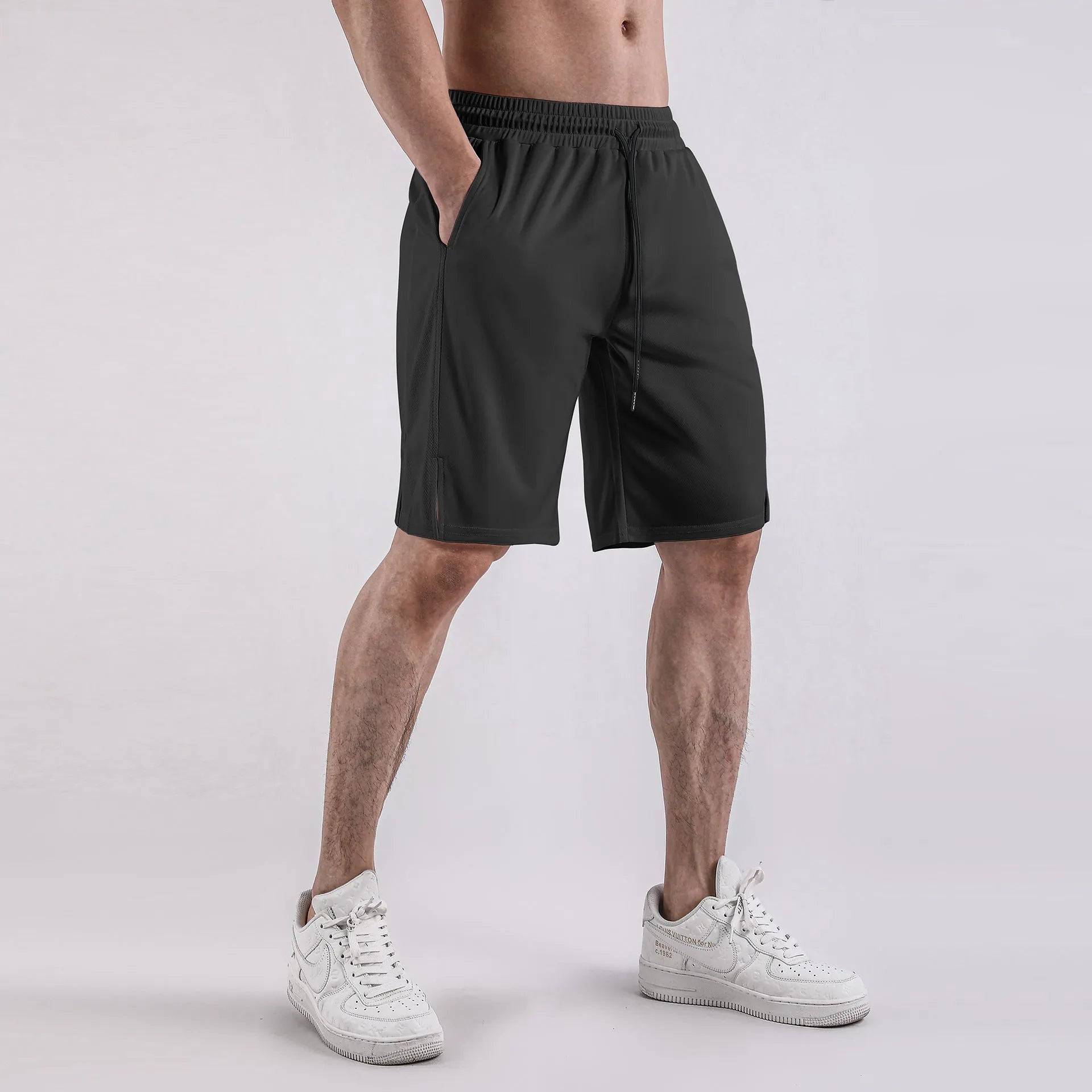 Men's black quick-dry mesh shorts with elastic waistband on a neutral background.
