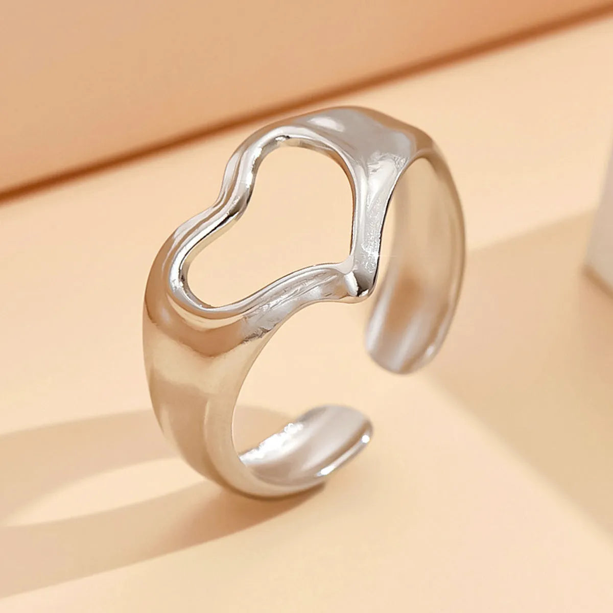 Adjustable hollow heart open ring in stainless steel with U-shaped band and rose motif, shown in steel or gold colour