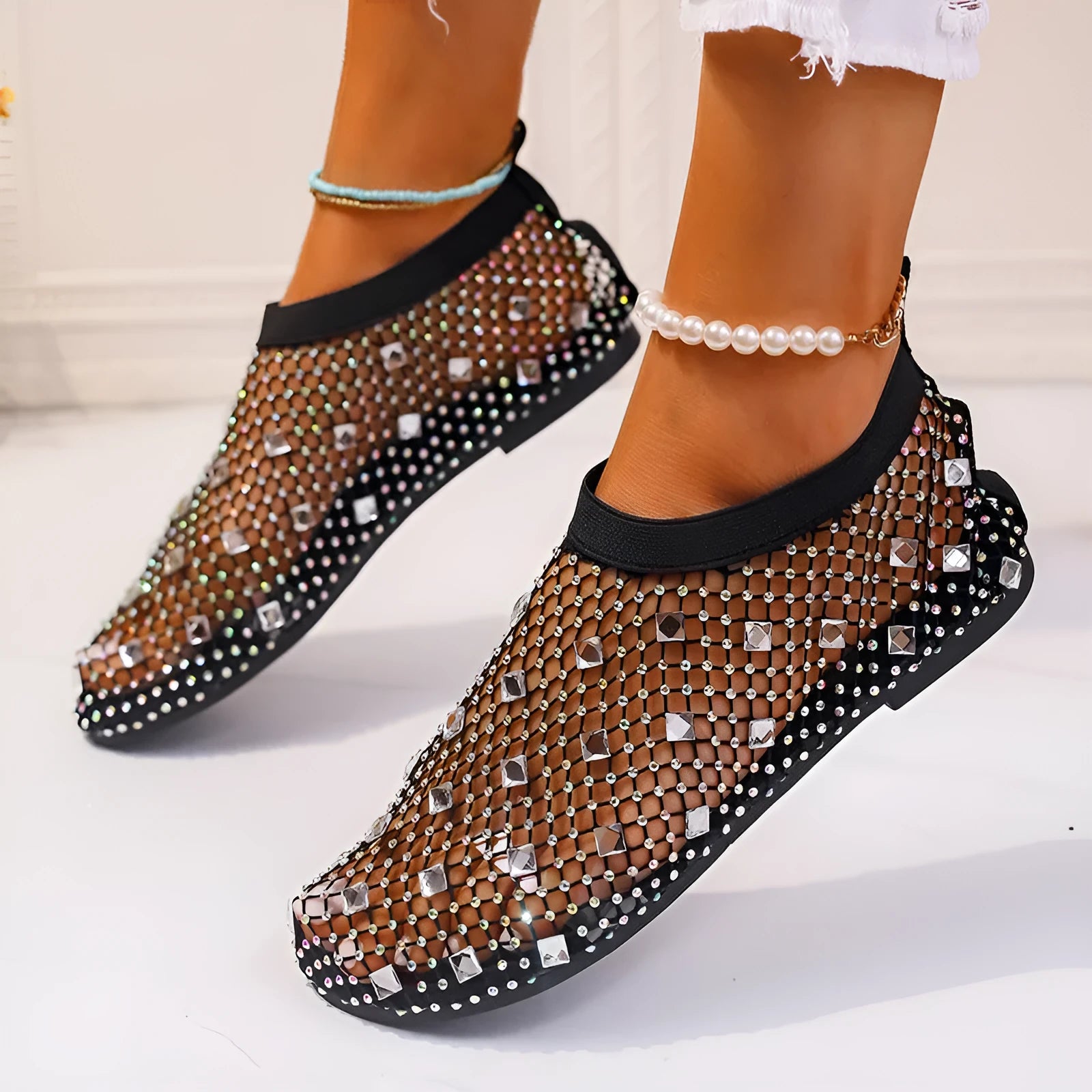 Colourful rhinestone detail on women's white mesh flat sandals with a rubber sole.
