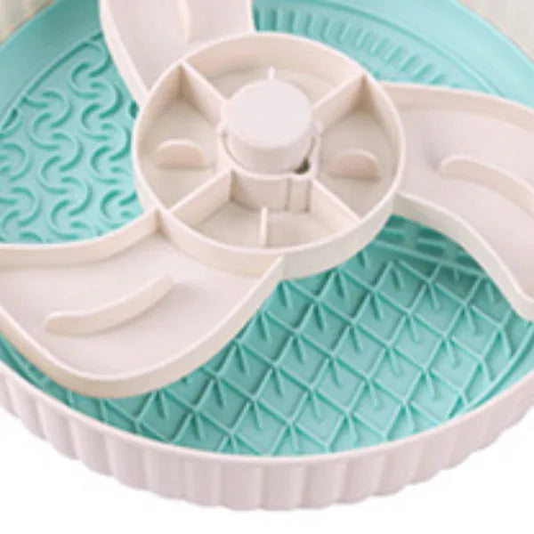 Grey pet slow feeder bowl with rotating windmill-pattern top and a white anti-choke silicone pad in the centre.
