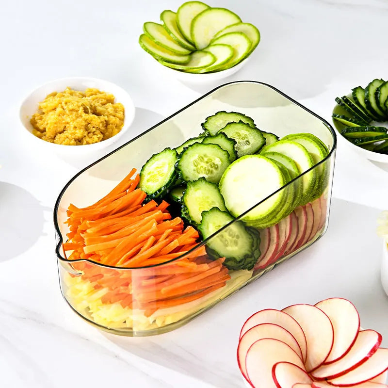 Transparent green vegetable chopper with multiple stainless steel blades and an optional white drain basket on a kitchen counter.
