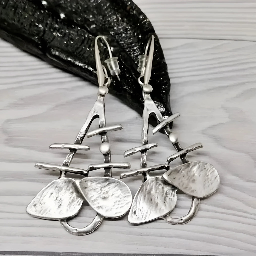 Retro creative leaves hollow step pendant earrings in silver alloy with irregular leaf shape for women's fashion