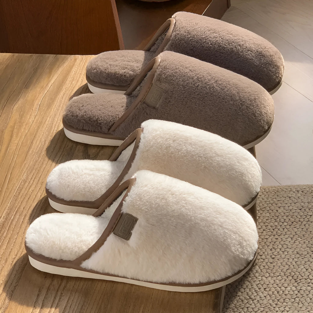 Pair of solid-colour plush winter slippers with a PVC upper and textured non-slip sole.