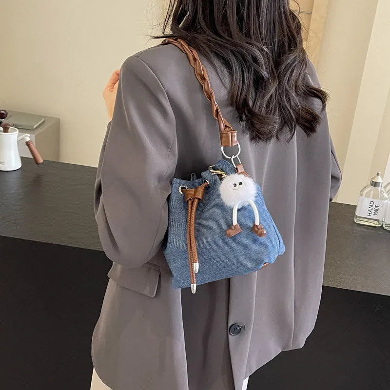 Blue synthetic leather cross-body bucket bag with adjustable strap and outer pocket