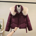 Women's short black quilted jacket with a stand-up collar on a hanger.