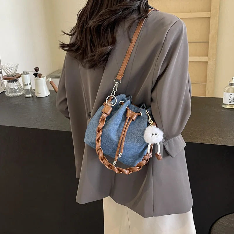 Blue synthetic leather cross-body bucket bag with adjustable strap and outer pocket