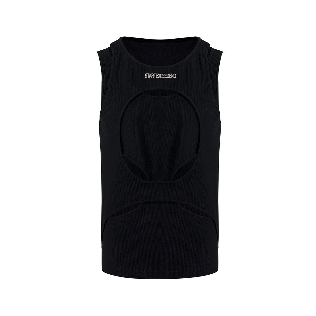 Man wearing a loose-fitting black sleeveless waistcoat with a round neck over a white t-shirt.