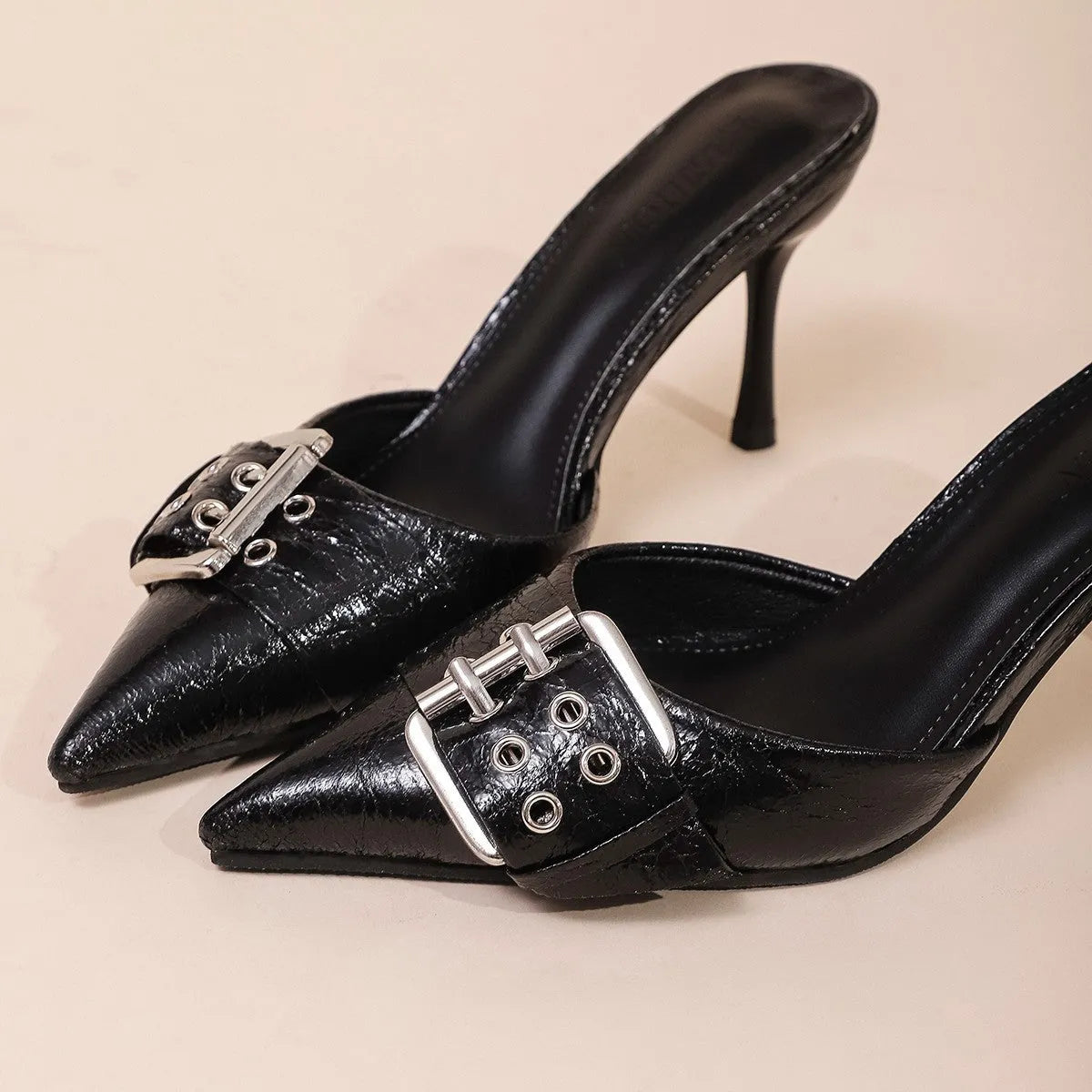 Black women's high heel shoes with pointed toe and buckle strap decoration.
