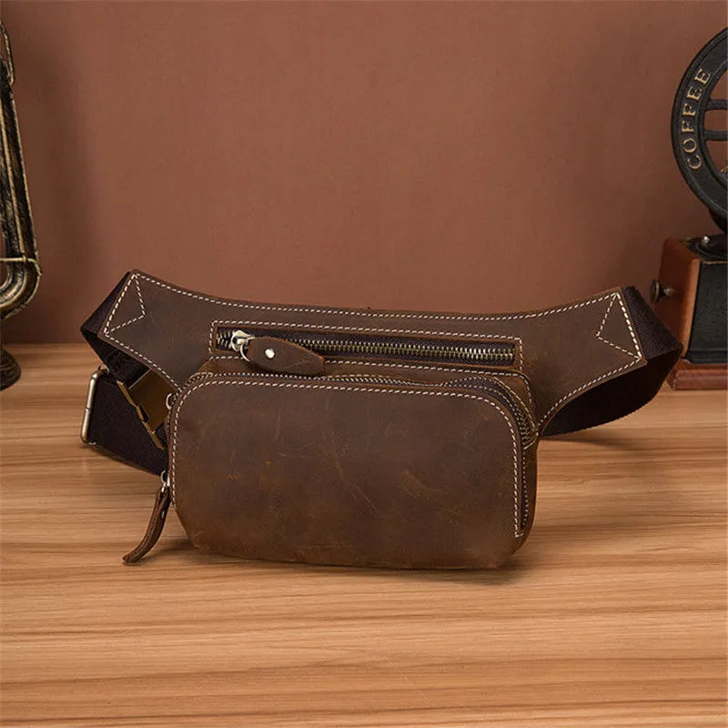 Brown cowhide leather men's waist bag showing pull-closure, worn on hip, with internal phone pouch visible.