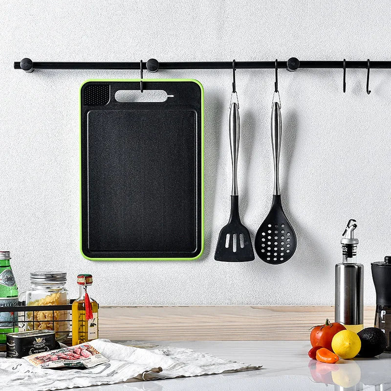 Grey square aluminium cutting board with double-sided design showing thawing surface and integrated knife sharpener