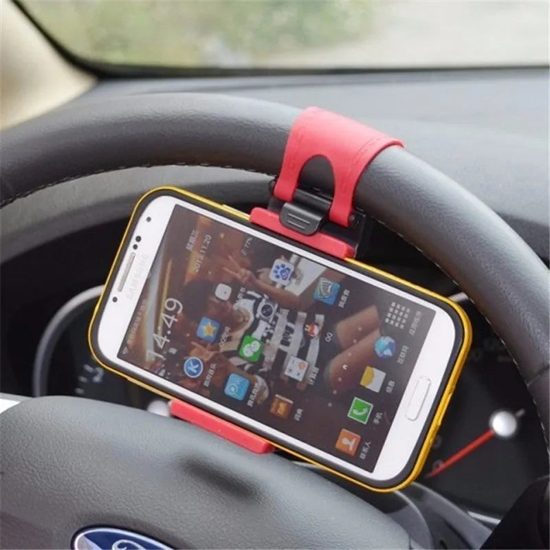 Black universal steering wheel phone clip holder with silicone pad mounted on a car steering wheel.