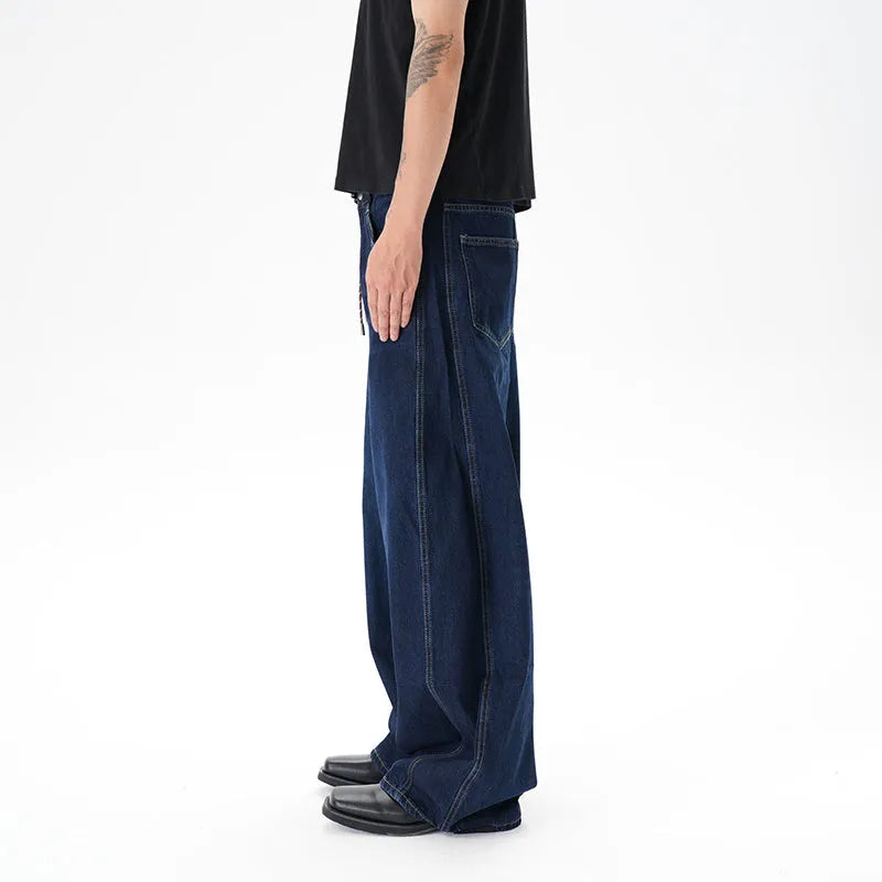 Dark blue washed distressed denim wide leg machete jeans laid flat, showing the wide leg cut and textured finish.
