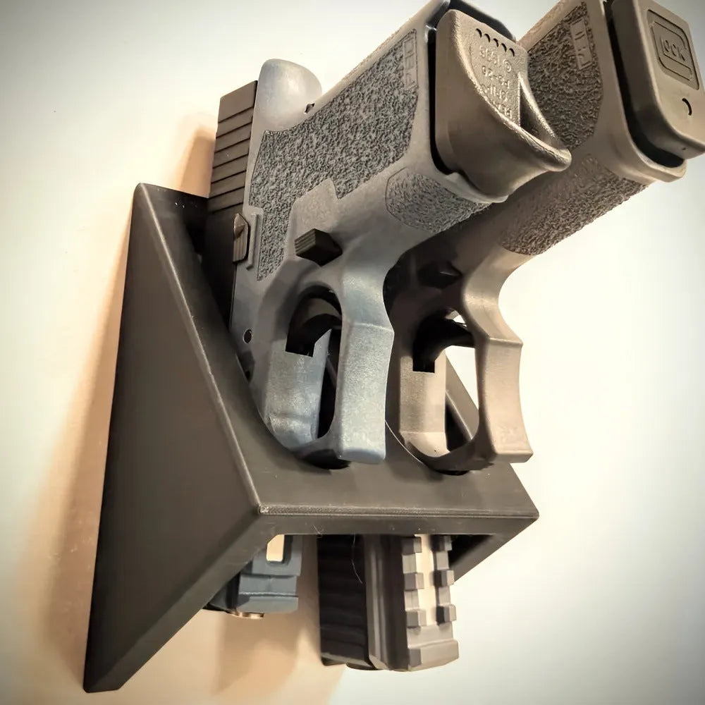 Black punk-style plastic pistol display stand measuring 10.85 by 7.6 centimetres.