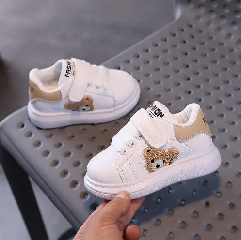 Children's black sports shoes with a cartoon bear design on the artificial leather upper and a rubber sole.