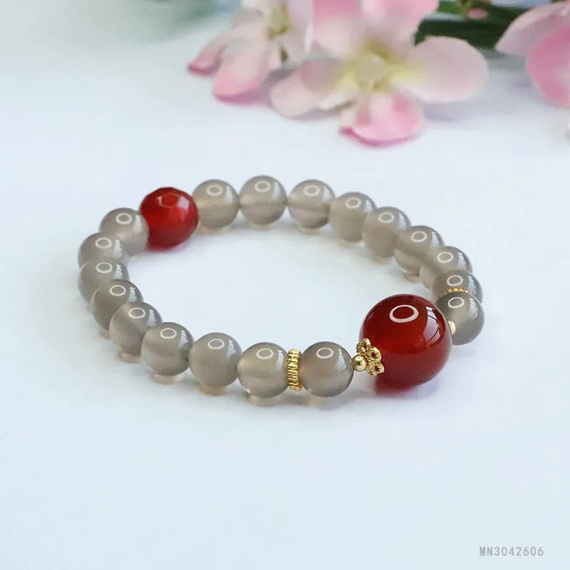 Smoky purple and red agate bracelet with 8mm geometric beads on a white background.