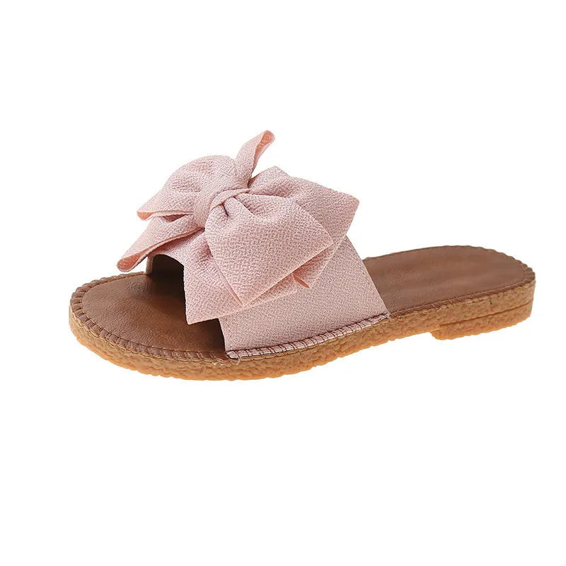 Women's beige suede slip-on sandals with a flat heel and soft bottom on a light background