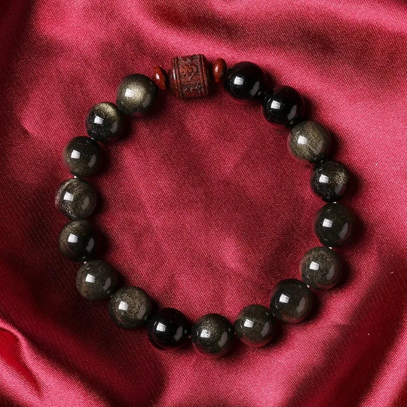 Close-up of a hand-woven Better Luck Beads bracelet with 10mm round Golden Obsidian beads in a retro style.