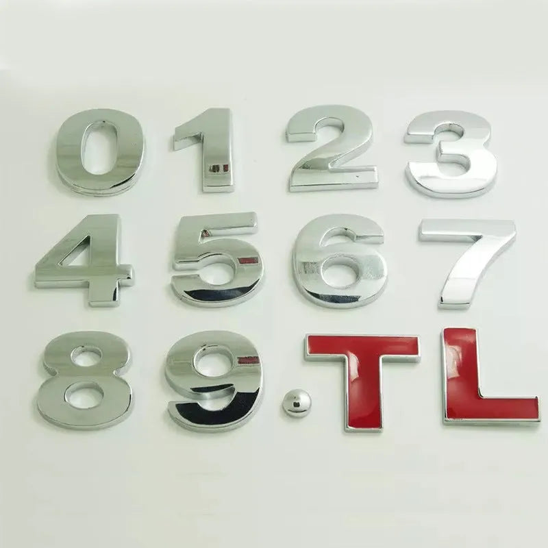 Close-up of a black zinc alloy 3D letter 'A' car bumper sticker on a silver vehicle panel.